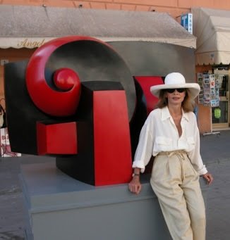Escultora griega Sophia Vari posa frente a la escultura la toute petite